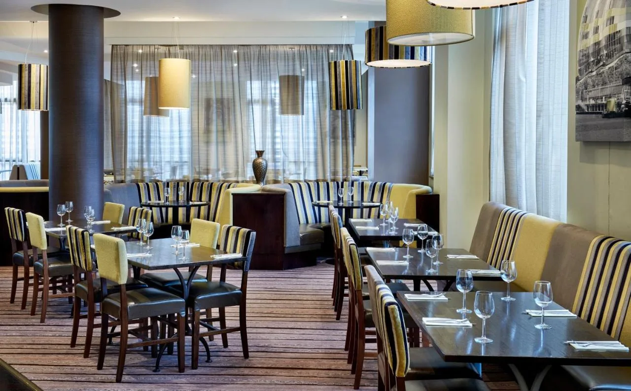 a restaurant with tables and chairs in a room at Leonardo Hotel Newcastle in Newcastle upon Tyne