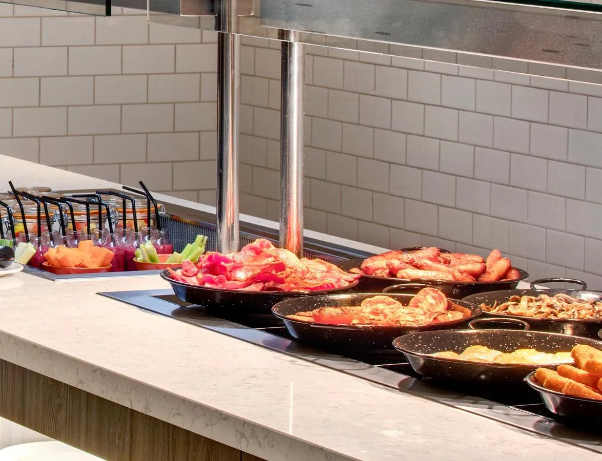 a buffet line with many different types of food in pans at Leonardo Hotel Newcastle in Newcastle upon Tyne