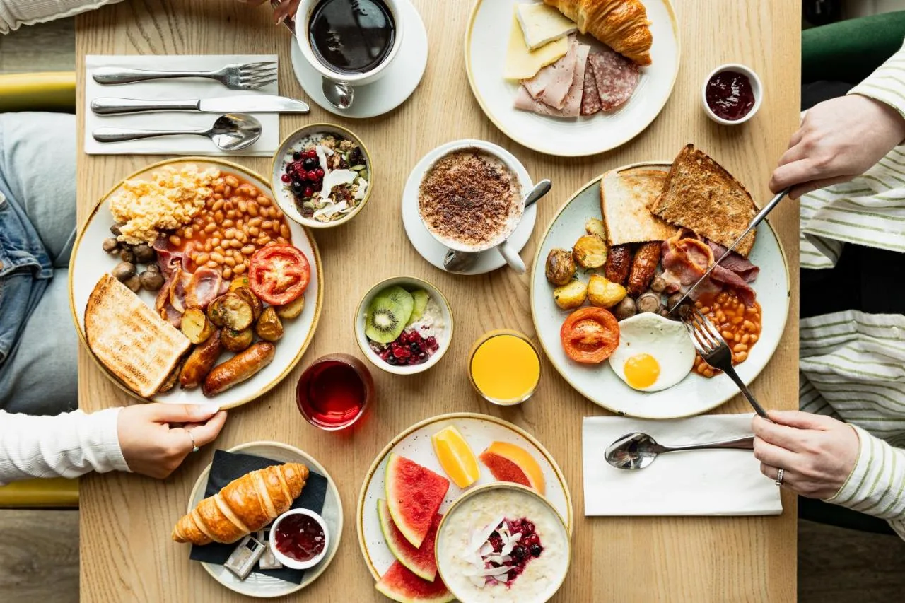 a table with plates of breakfast food on it at Leonardo Hotel Newcastle in Newcastle upon Tyne