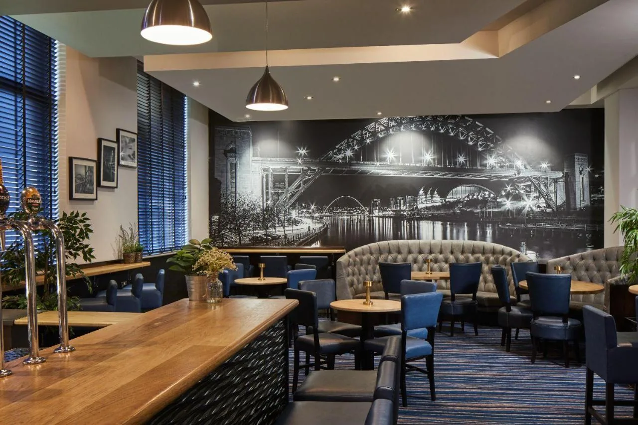 a restaurant with chairs and tables and a mural of a bridge at Leonardo Hotel Newcastle in Newcastle upon Tyne